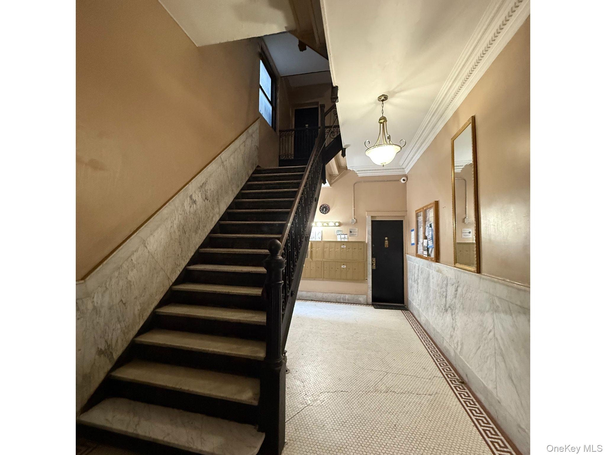 501 West 156th Street, Unit 22 Manhattan, NY 10032 - Photo 2 of 13 Stairs with crown molding and a wainscoted wall