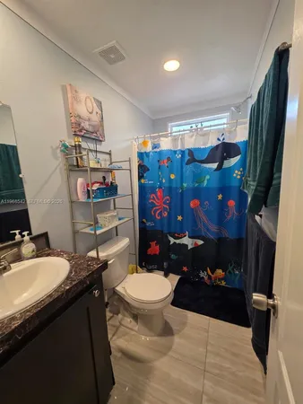 a bathroom with a sink mirror vanity and toilet