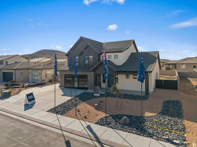 Modern two-story residence featuring a dark gray roof, white stucco, and dark siding accents