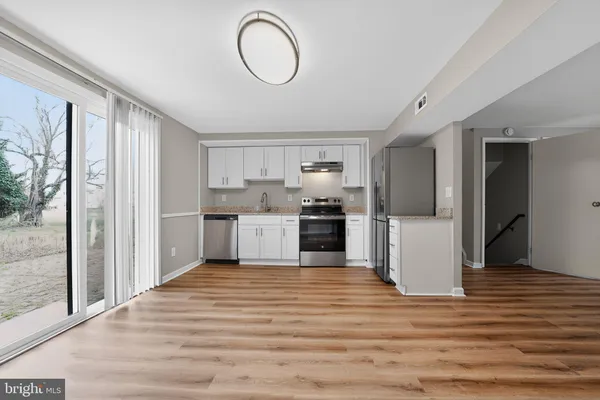 a kitchen with stainless steel appliances granite countertop a refrigerator and a sink