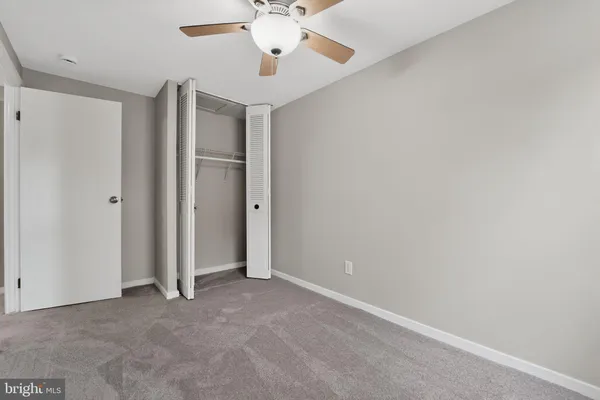 an empty room with a ceiling fan and a window