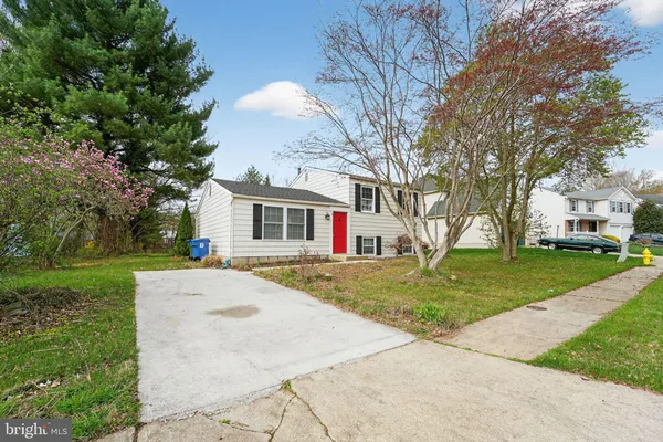 a front view of a house with a yard and trees