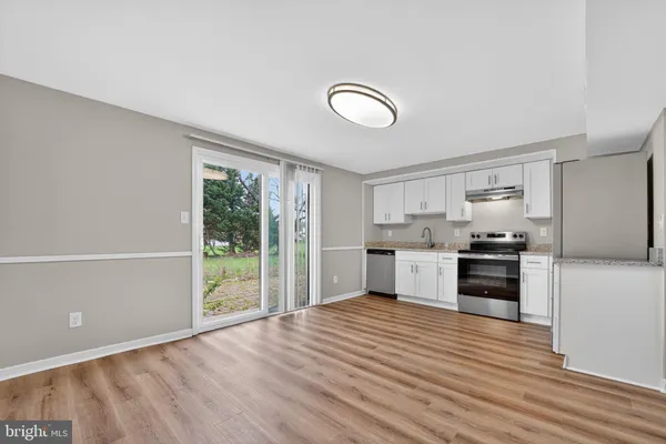 a kitchen with granite countertop a refrigerator and a stove top oven