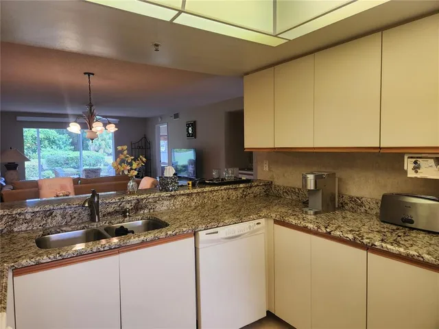 a kitchen with sink a window and cabinets