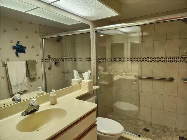 a bathroom with a sink shower and a mirror