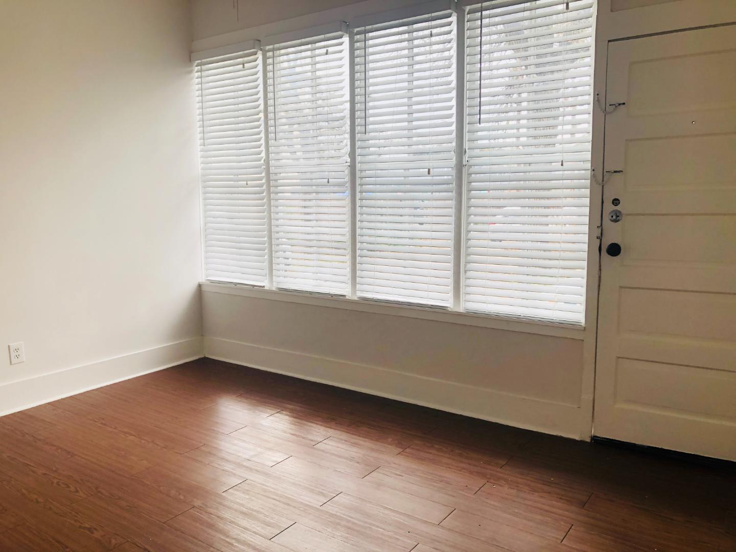 207 West 39th Street, Unit MAIN Austin, TX 78751 - Photo 3 of 7 Rich hardwood floors complement large windows, creating a welcoming and naturally illuminated living space.