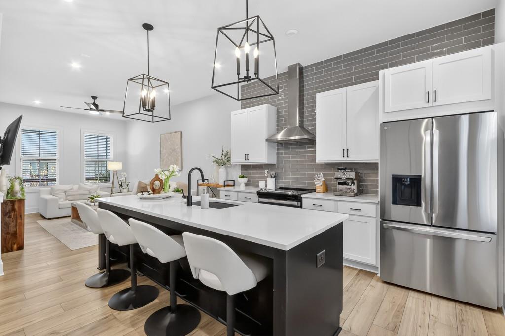 4455 Dandelion Lane Atlanta, GA 30342 - Photo 11 of 44 a kitchen with stainless steel appliances a dining table chairs stove refrigerator and cabinets