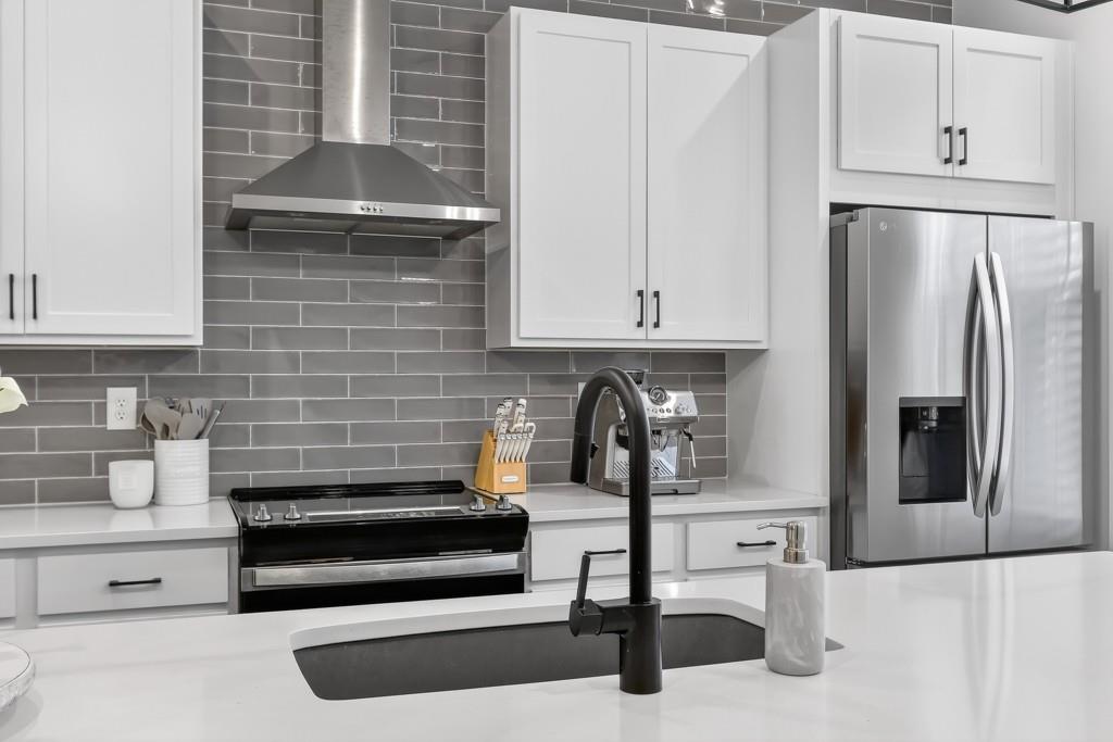 4455 Dandelion Lane Atlanta, GA 30342 - Photo 12 of 44 a kitchen with granite countertop white cabinets and stainless steel appliances