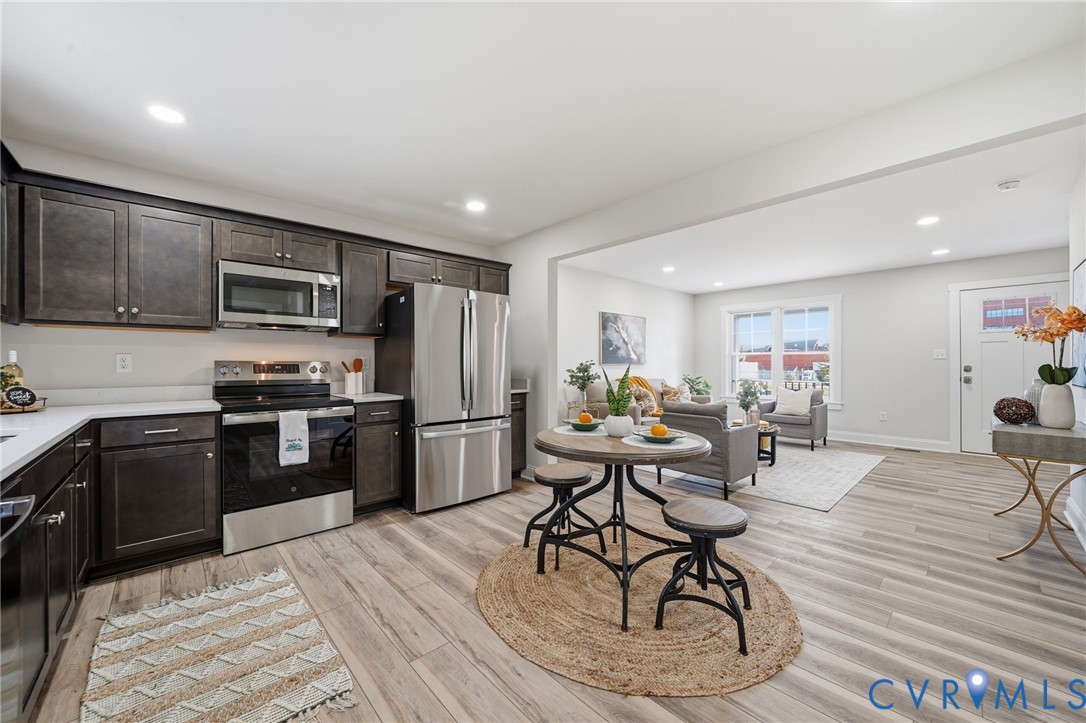 2914 Congress Road North Chesterfield, VA 23237 - Photo 5 of 23 a kitchen with stainless steel appliances kitchen island granite countertop a stove a refrigerator a sink a dining table and chairs with wooden floor
