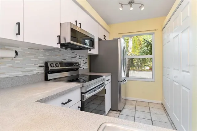 a kitchen with stainless steel appliances a stove microwave and sink