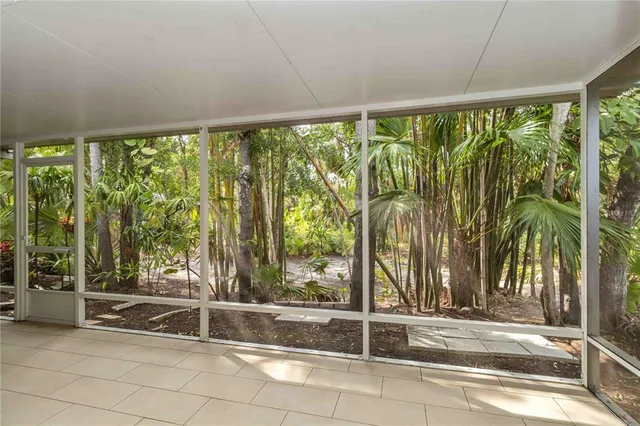 a living room with a floor to ceiling window and an outdoor view
