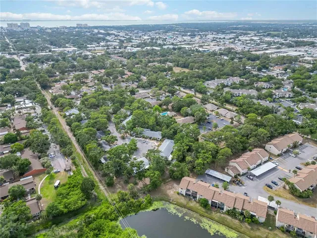 an aerial view of residential houses with outdoor space and trees