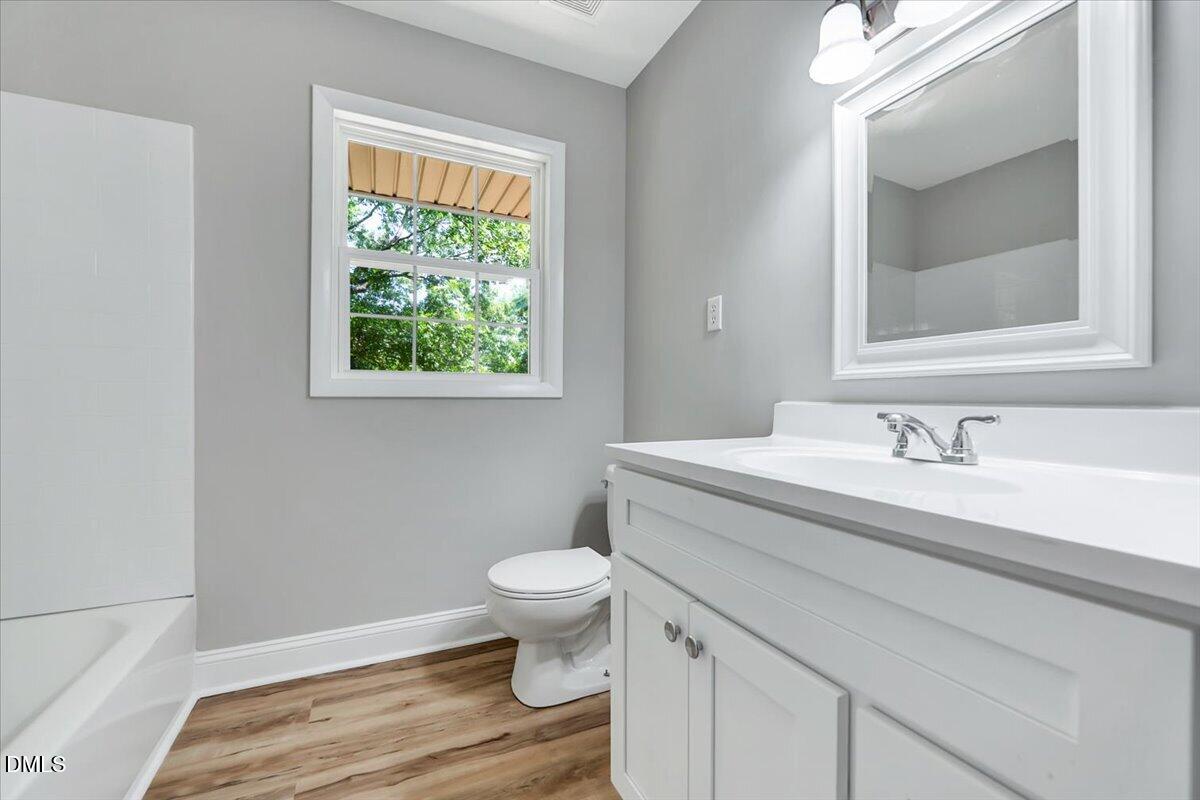 3408 Atlantic Avenue Raleigh, NC 27604 - Photo 15 of 48 a bathroom with a granite countertop toilet sink and mirror