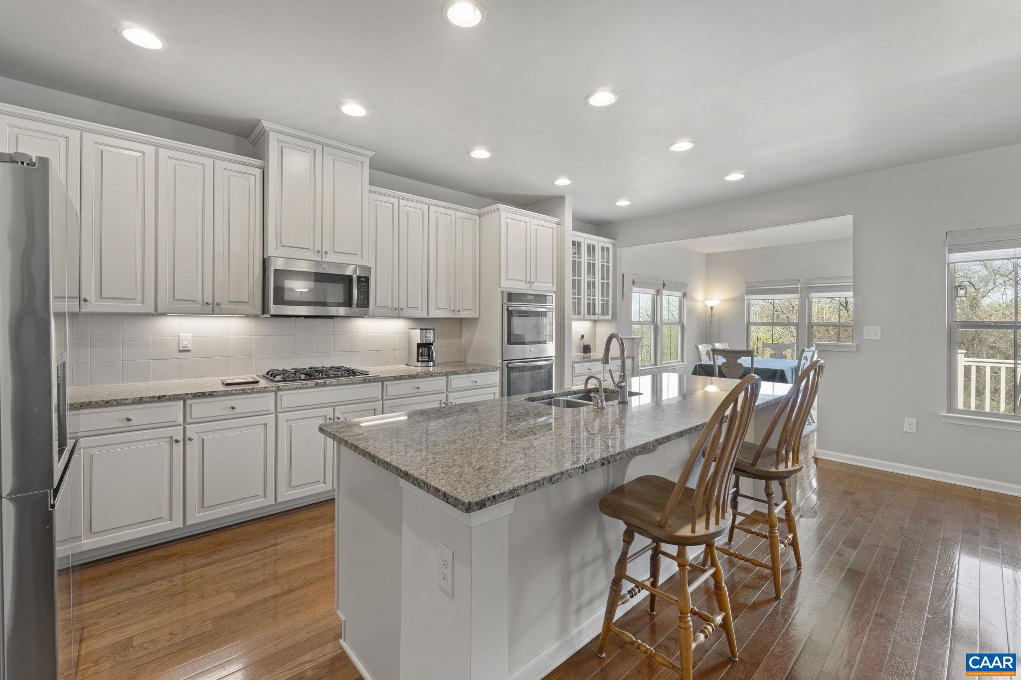 1377 Delphi Lane Charlottesville, VA 22911 - Photo 11 of 48 a kitchen with kitchen island granite countertop wooden floor white cabinets and appliances