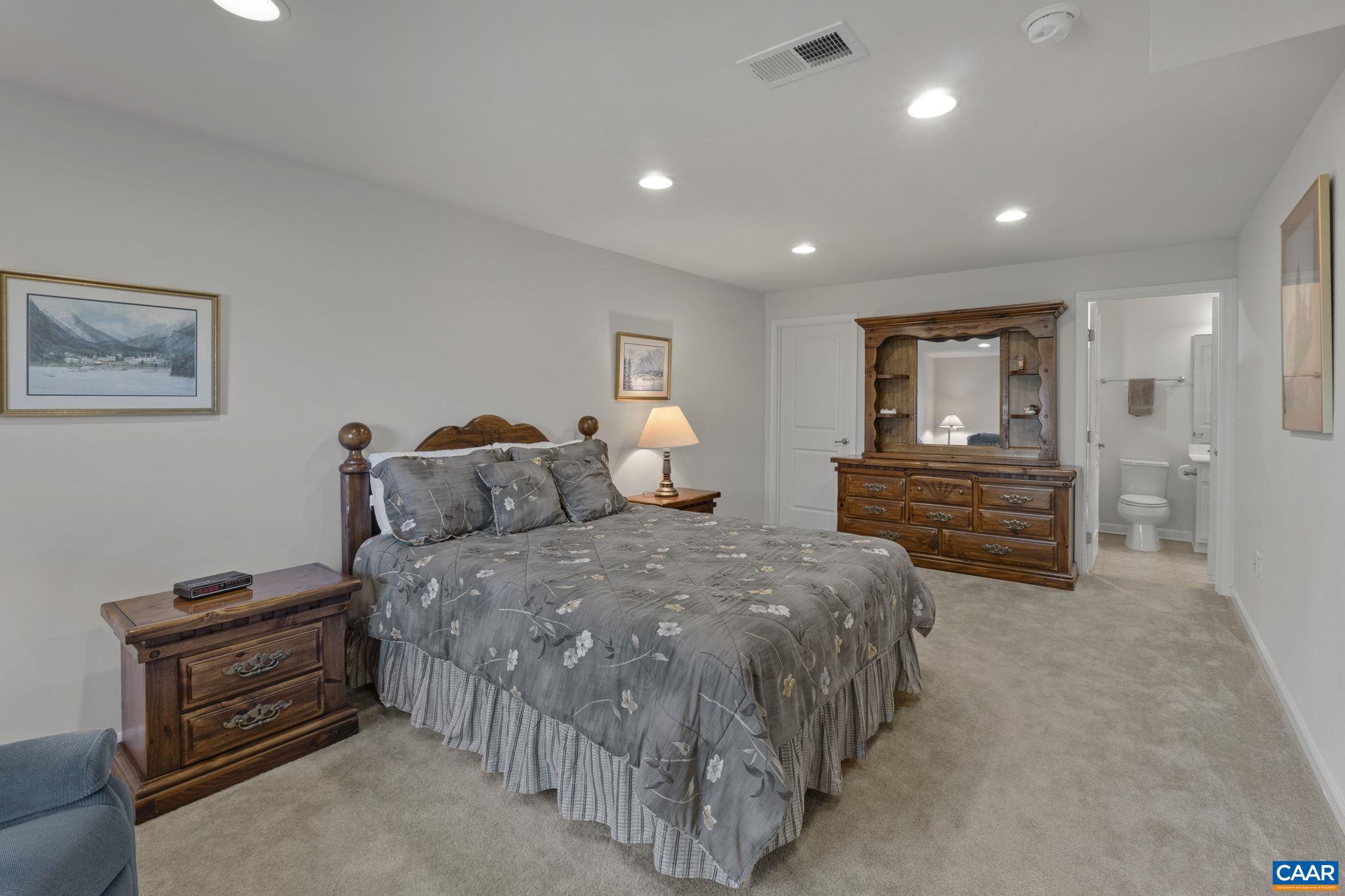 1377 Delphi Lane Charlottesville, VA 22911 - Photo 36 of 48 a spacious bedroom with a bed and a chandelier