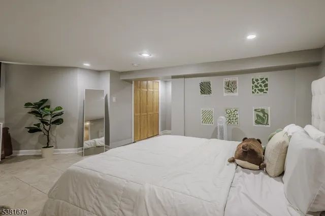 a bedroom with a large bed and a potted plant