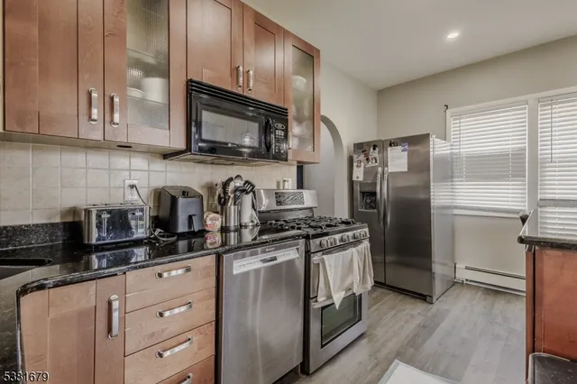 a kitchen with stainless steel appliances granite countertop a refrigerator stove a sink dishwasher and microwave oven with cabinets