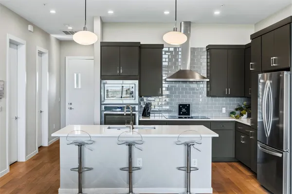 a kitchen with stainless steel appliances granite countertop a sink refrigerator and cabinets