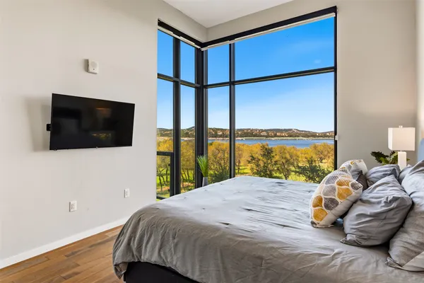 a bedroom with a bed and a lamp on dresser