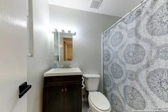 a bedroom with a bed chandelier and a window