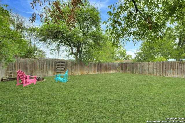 a backyard of a house with table and chairs