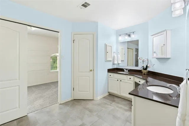 a bathroom with a granite countertop sink a bathtub and next to a window