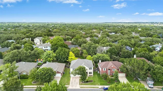 an aerial view of a house with a yard and trees