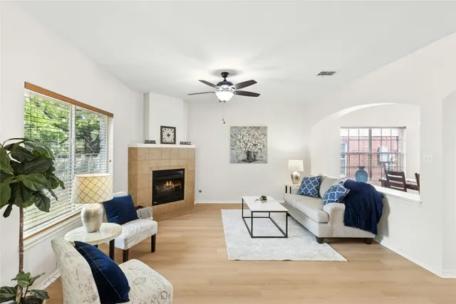 a living room with furniture a fireplace and a large window
