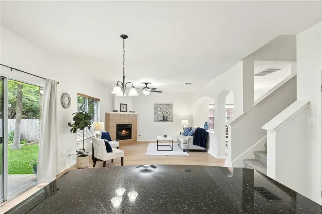 a living room with furniture a fireplace and a chandelier