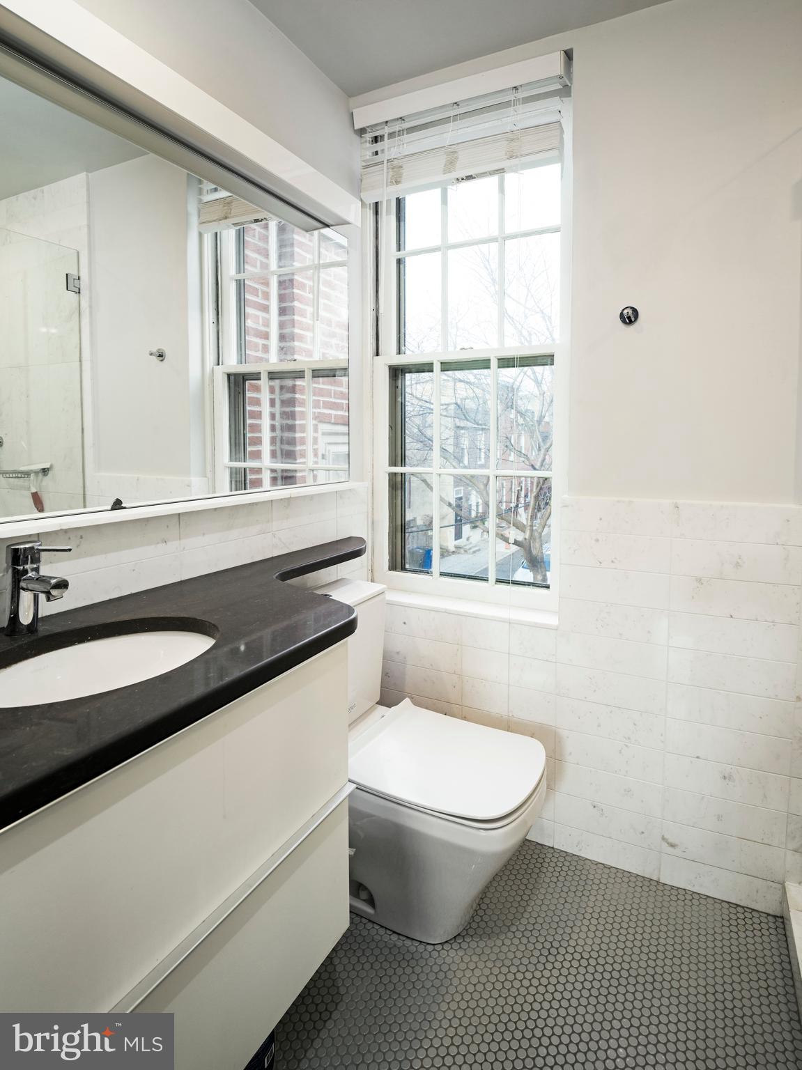 223 Carpenter Street Philadelphia, PA 19147 - Photo 29 of 42 a bathroom with a sink a toilet and a window