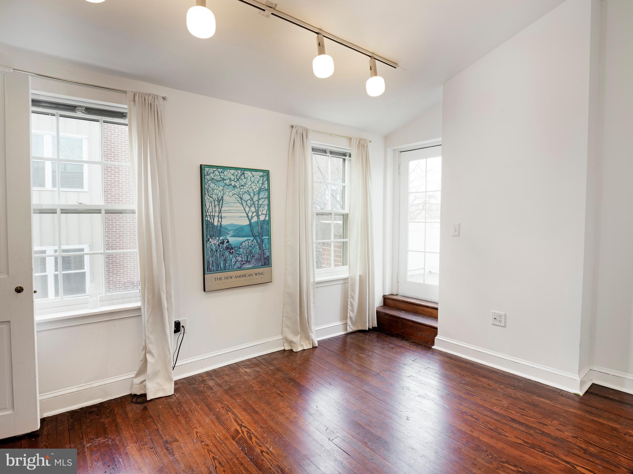 223 Carpenter Street Philadelphia, PA 19147 - Photo 32 of 42 an empty room with wooden floor and windows