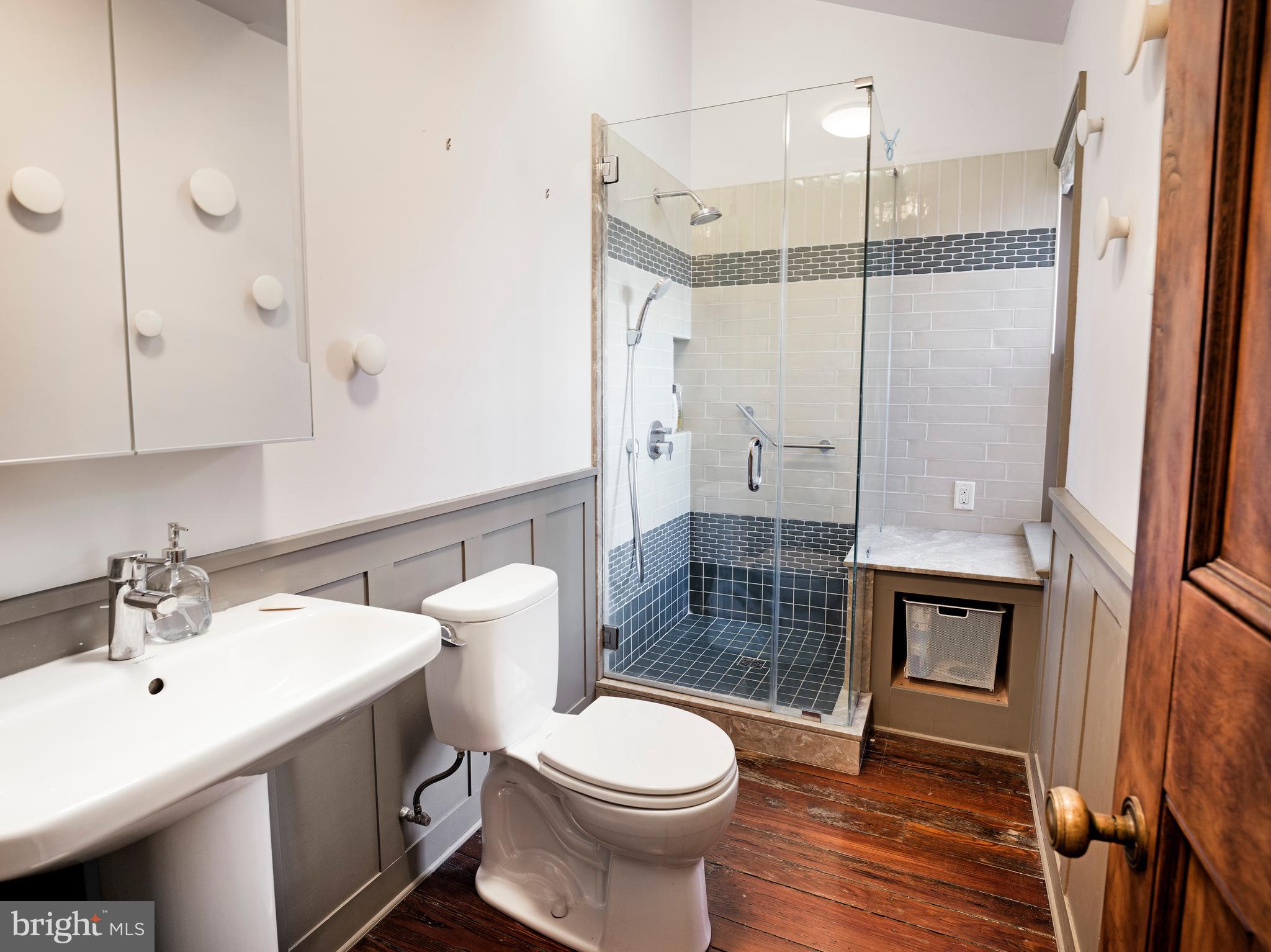 223 Carpenter Street Philadelphia, PA 19147 - Photo 40 of 42 a bathroom with a toilet a sink a glass door shower and mirror