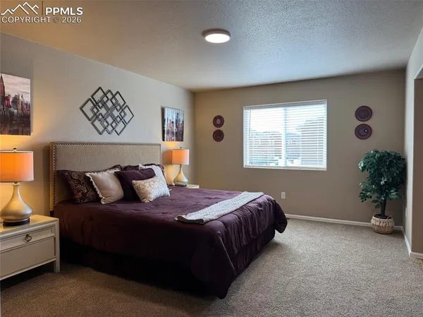 a bedroom with a bed and a potted plant