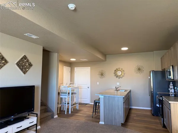 a kitchen with kitchen island granite countertop a sink stove and refrigerator