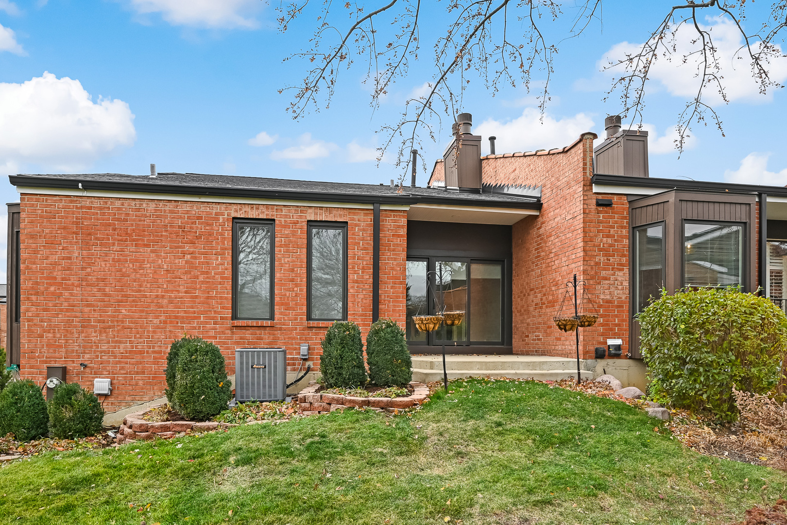 2-s719 Williamsburg Court Oak Brook, IL 60523 - Photo 11 of 48 a view of a house with brick walls and a yard with plants