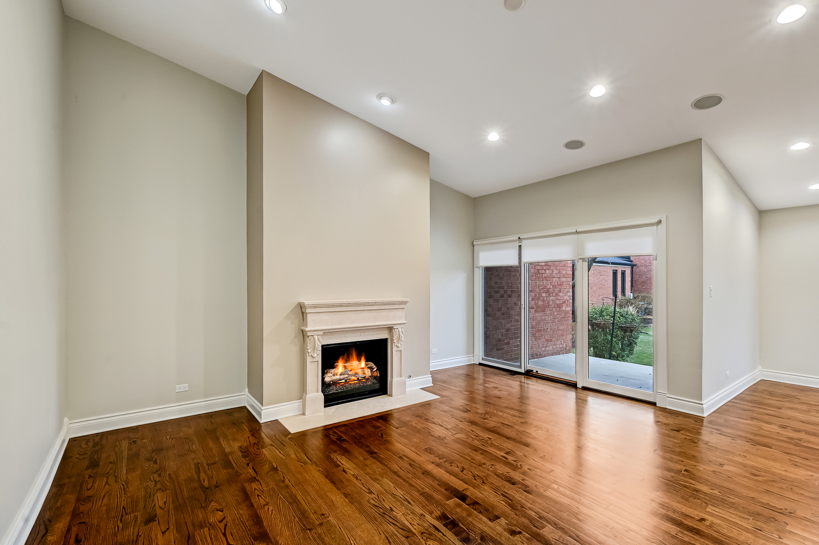 2-s719 Williamsburg Court Oak Brook, IL 60523 - Photo 13 of 48 a view of an empty room with wooden floor fireplace and a window