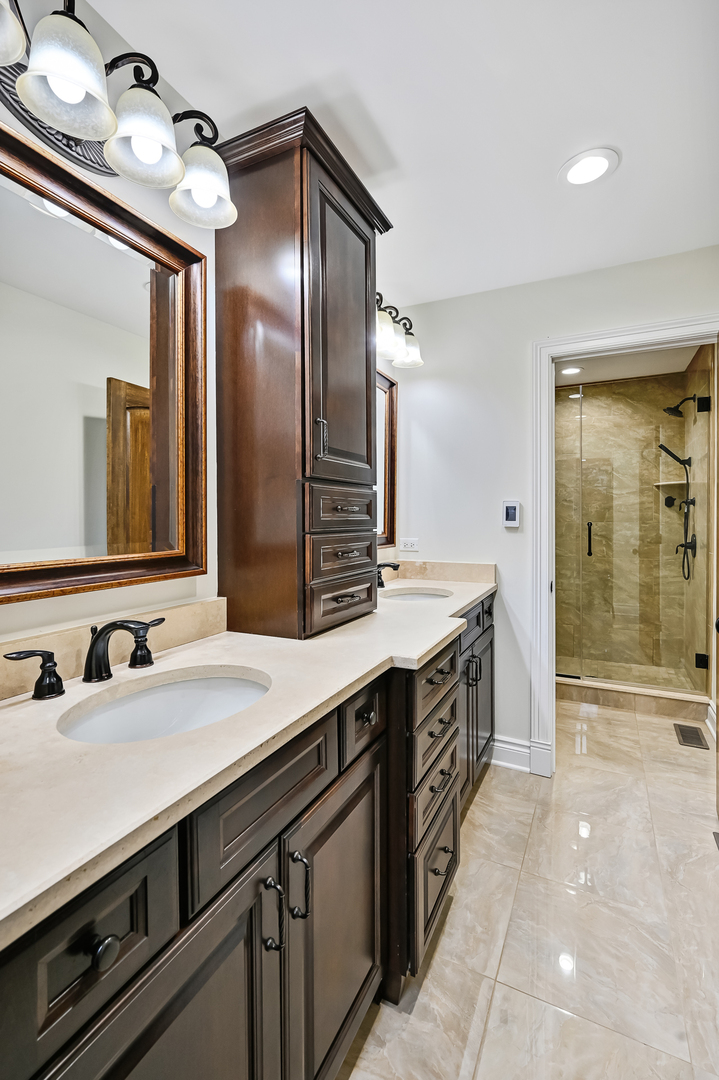 2-s719 Williamsburg Court Oak Brook, IL 60523 - Photo 26 of 48 a spacious bathroom with double vanity and a mirror