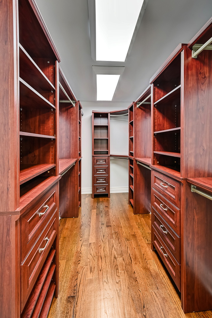2-s719 Williamsburg Court Oak Brook, IL 60523 - Photo 28 of 48 a view of walk in closet with clothes and shoes