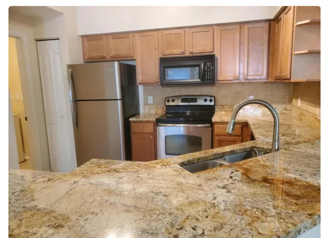 a kitchen with a refrigerator sink and cabinets