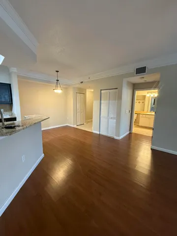 a view of a kitchen with a fridge and wooden floor