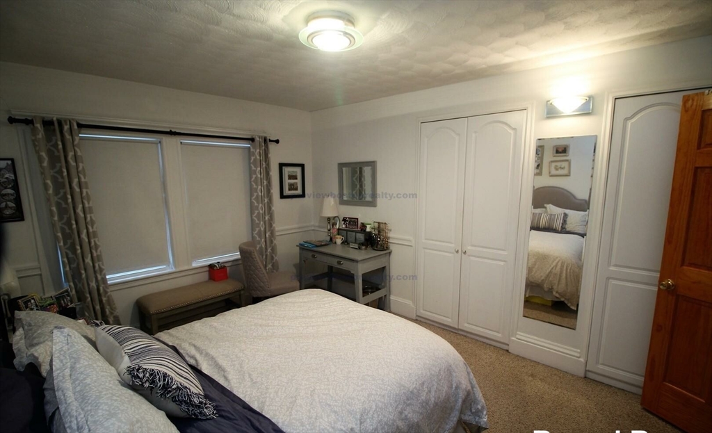 504 Washington Street, Unit 1 Brookline, MA 02446 - Photo 13 of 13 a bedroom with a bed and a refrigerator