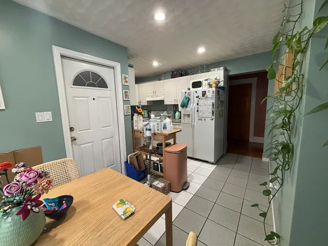 a kitchen with stainless steel appliances a refrigerator a sink and white cabinets