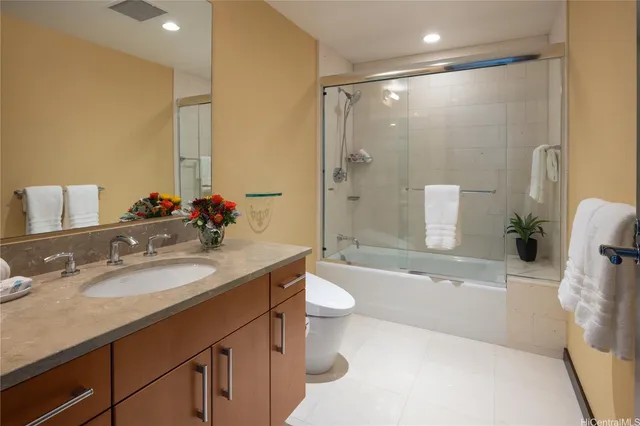 a bathroom with a granite countertop sink toilet and shower
