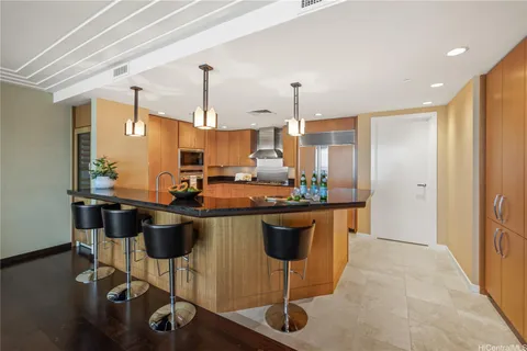 a kitchen with stainless steel appliances granite countertop a stove a sink dishwasher and a refrigerator with wooden floor