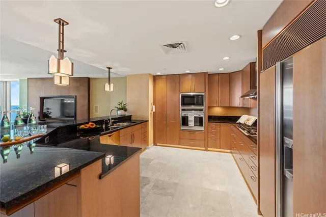 a kitchen with stainless steel appliances granite countertop a sink refrigerator and cabinets