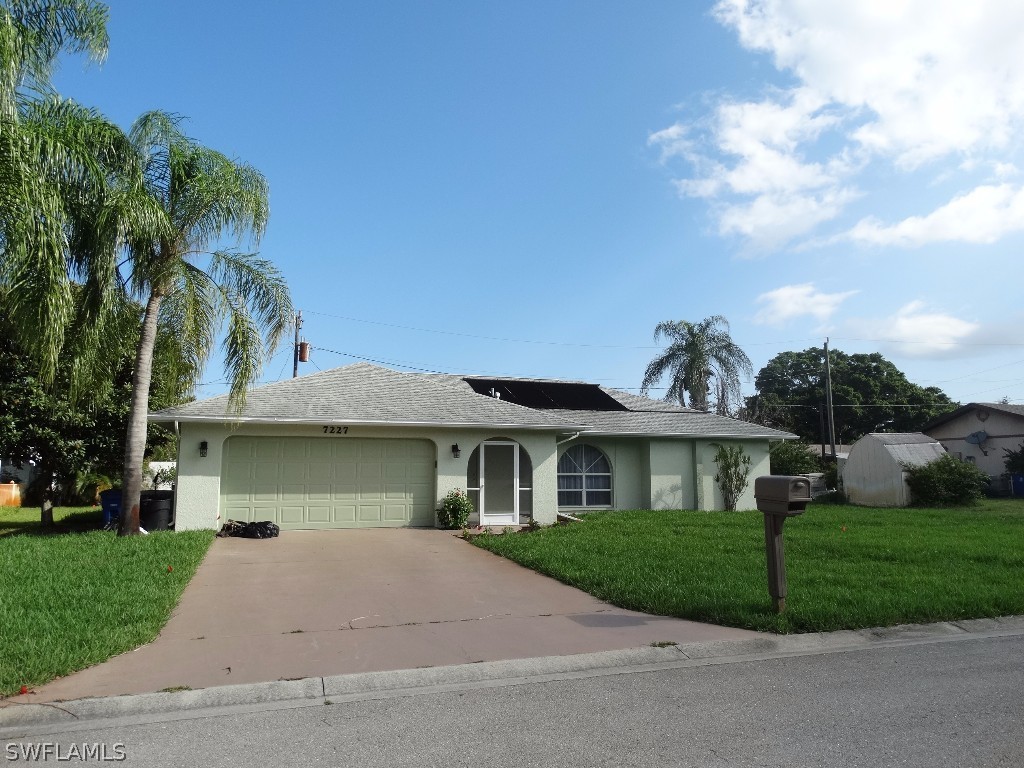 7227 Coolidge Road Fort Myers, FL 33967 - Photo 1 of 24 a front view of a house with a yard and garage