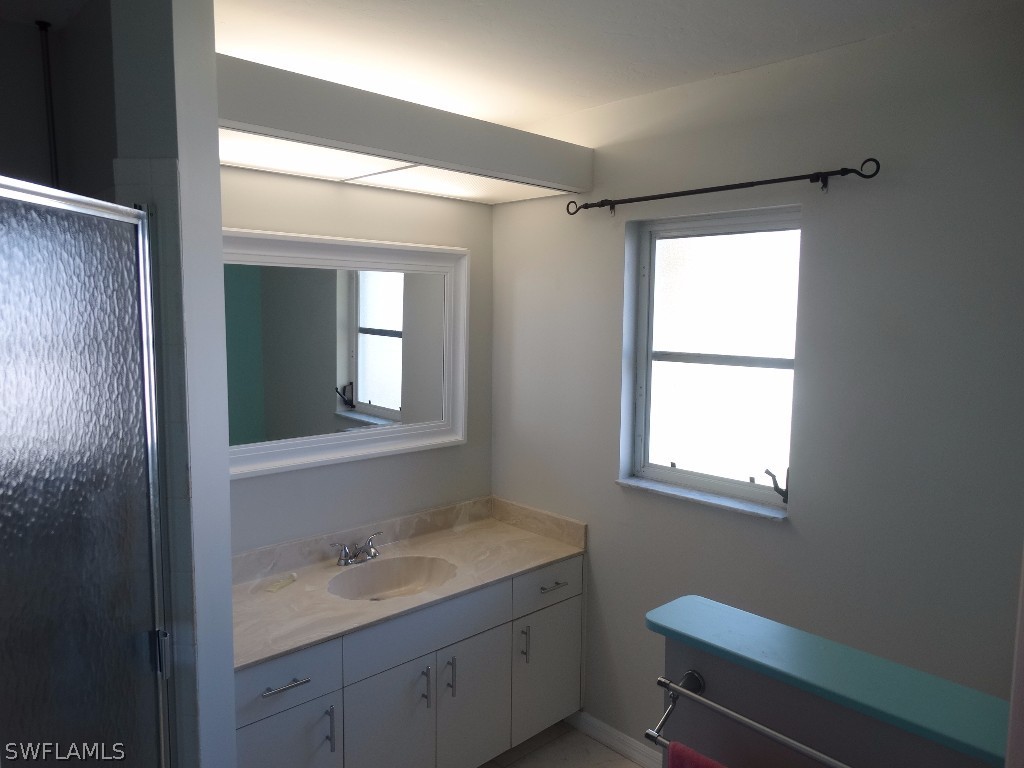 7227 Coolidge Road Fort Myers, FL 33967 - Photo 13 of 24 a bathroom with a toilet sink vanity and mirror