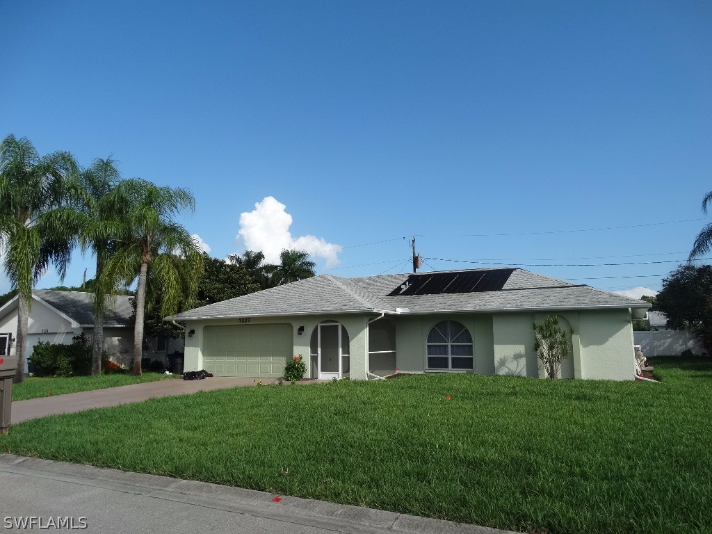 7227 Coolidge Road Fort Myers, FL 33967 - Photo 2 of 24 a front view of a house with a garden and plants