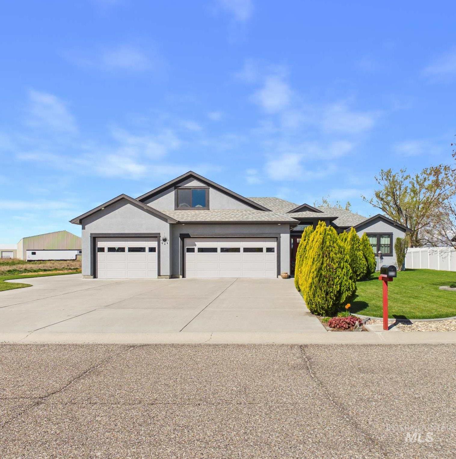 View of front of home featuring a front yard, a garage, and concrete driveway