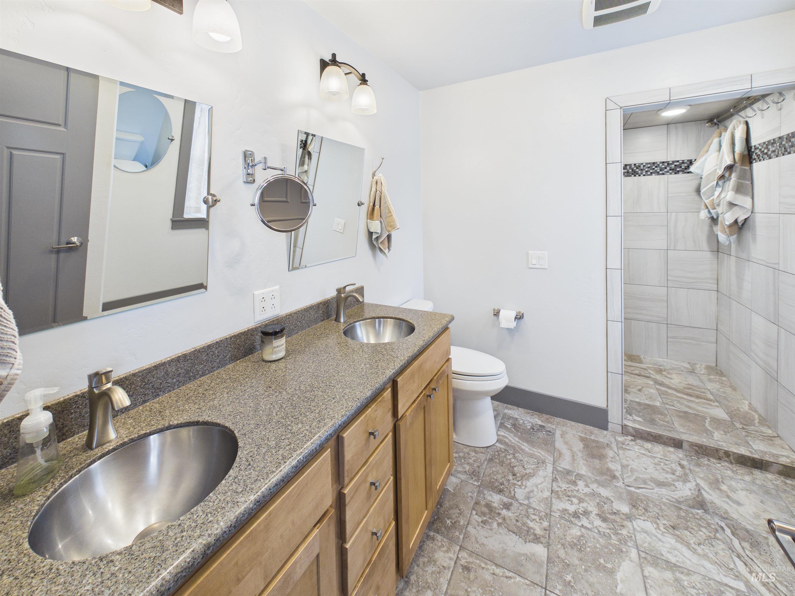 503 Heron Way Rupert, ID 83350 - Photo 18 of 49 Bathroom with double vanity, walk in shower, and light stone finish flooring